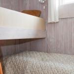 Obere und untere Schlafcouch mit Holzgestell und floraler Bettwäsche.