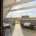 Terrasse mit Tisch, Stühlen und Blick auf das Feld und Haus.