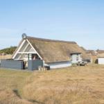 Dorfhaus mit Strohdach, Terrasse und Picknicktisch im Grasland