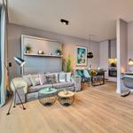 Wohnbereich mit Sofa, Esstisch und Arbeitsplatz. Holzboden und große Fenster.