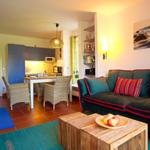 Wohnzimmer mit Sofa, Couchtisch und Küchenbereich im Hintergrund.