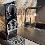 Küchenbereich mit Nespresso-Kaffeemaschine und modernem Wasserhahn.
