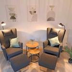 Zwei graue Sessel mit Fußhocker und kleinem Tisch