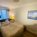 Schlafzimmer mit Bett, Fenster und Wandbild.