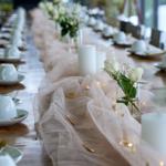 Langtisch mit Tischdecke, Kerzen und Blumen für Gäste