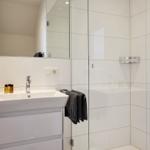 Badezimmer mit Dusche, Waschbecken und Spiegel