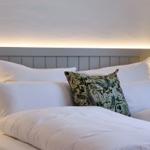 Bettkopfteil mit LED-Beleuchtung und Kissen.