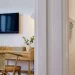 Schreibtisch mit Stuhl, Fernseher und Blumen