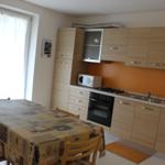 Küche mit Essbereich, Holztisch, Mikrowelle und Ofen