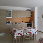 Küche mit Esstisch, Mikrowelle und Kochfeld.