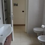 Badezimmer mit Waschbecken, WC und Bidet. Fliesenboden und Wandfliesen.