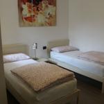 Zwei Einzelbetten mit gemusterten Bettwäsche und einer Wanddekoration.