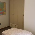 Schlafzimmer mit Bett, Kleiderschrank und Wandkarte Europas.