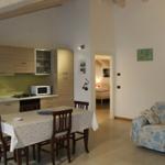 Küche mit Esstisch, Wohnbereich mit Sofa und Blick in Schlafzimmer.