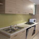 Küche mit Arbeitsplatte, Spüle, Herd und Mikrowelle.