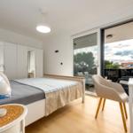Bedroom with bed, closet, and view of balcony