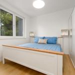 Bedroom with bed, window, and wardrobe.