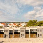 Modern vacation apartments with sea and surrounding buildings view.