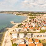Aerial view of coastal town with houses and clear sea.