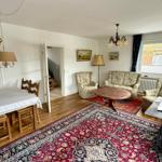 Wohn- und Essbereich mit Holzboden, Teppich und Möbeln.