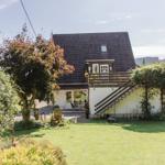 Haus mit Garten, Terrasse und Holzstufen zur Veranda.
