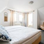 Schlafzimmer mit Doppelbett, Sofa und Fenstern