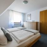 Schlafzimmer mit Doppelbett, Fenster und Holzschrank