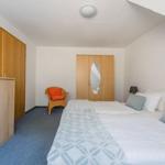 Schlafzimmer mit Bett, Kleiderschrank und Stuhl