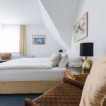 Schlafzimmer mit Bett, Nachttisch und Fenster unter Dachschräge