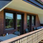 Terrace with table, chairs, and view of forest.