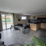 Wohn- und Küchenbereich mit Sofa, Kücheninsel und Terrassentür.