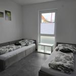 Zwei Einzelbetten mit floraler Bettwäsche und Fenster mit Jalousie.