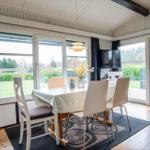 Dining room with table, chairs, and windows to the outdoor terrace.