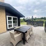 Terrace with table, chairs, loungers, and garden area.