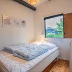 Bedroom with bed, window, and wall art.