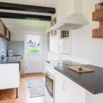 Kitchen with worktop, sink, and extractor. Passage to apartment with door.