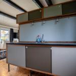 Kitchen with countertop, sink, and kettle. Dining area with table and chairs.