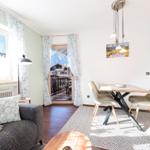 Wohn- und Essbereich mit Balkon, Sofa, Tisch und Stühlen.