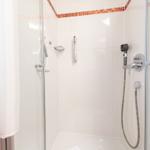 Dusche mit Glaswand, Handbrause und Handtuchhalter