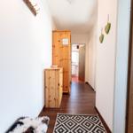 Flur mit Holzmöbeln, Teppich und Wanddekoration.