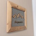 Holzrahmen mit Bergmotiv und Schrift Bergmensch an Wand