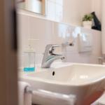 Waschbecken mit Wasserhahn und Seifenspender in Badezimmer