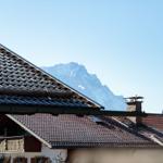 Dach mit Schornstein und Berg im Hintergrund