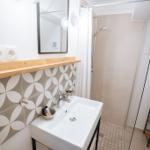 Badezimmer mit Waschbecken, Spiegel und Dusche