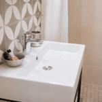 Waschbecken mit modernem Wasserhahn und dekorativen Fliesen im Badezimmer