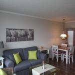 Wohnzimmer mit Sofa, Esstisch und Küchenbereich