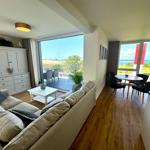 Wohn- und Essbereich mit Blick aufs Meer und Balkon.