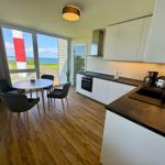 Küche mit Esstisch und Blick auf Leuchtturm und Meer