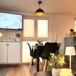 Küche und Essbereich mit TV, Tisch, Stühlen und Pflanzen.