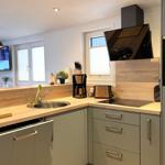 Küche mit Holzoberfläche, Spüle, Herd und integriertem Kühlschrank.